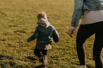 happy family having fun and jogging outdoors, mom and baby jogging in the park