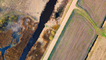 Top view of the river in the fields with the road
