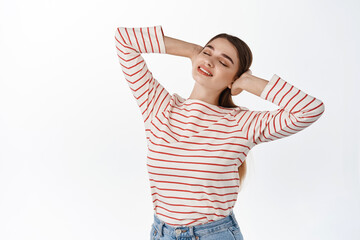 Beautiful smiling woman resting, holding hands behind head and close eyes, lying with dreamy smile and happy carefree expression, enjoying holidays, standing over white background