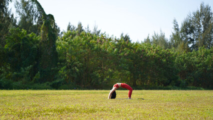 long range telephoto picture of asian chinese woman yoga yogi in the park
