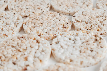 Fototapeta na wymiar Round diet crispbreads on a white background. Round shaped cereal bread, healthy food without yeast. Top view. Copy, empty space for text