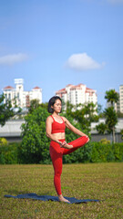 asian chinese female lady yogi practise yoga stretches poses in the park in beautiful weather