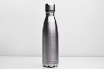 Metal flask for preservation of a hot or cold liquid on a white background. Stainless thermos water bottle, isolated on white background. Silver color. Blank stainless steel double wall workout bottle