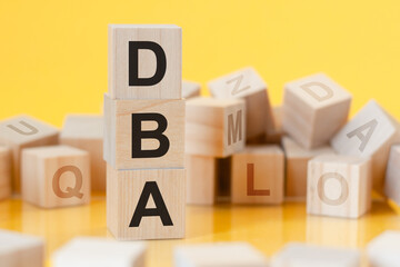 word dba from wooden blocks with letters, concept