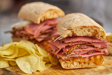 Pastrami sandwhich with delicious meet on baguette bread with chedder cheese, onion