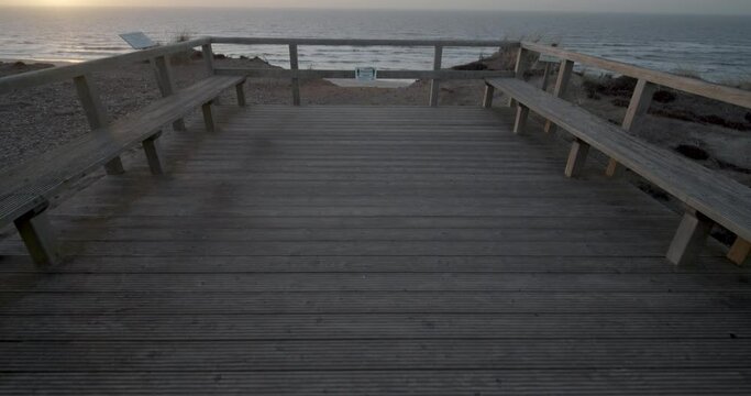 Slow motion gimbal tracking shot of the beach through the dunes of Kampen on Sylt while the sun sets