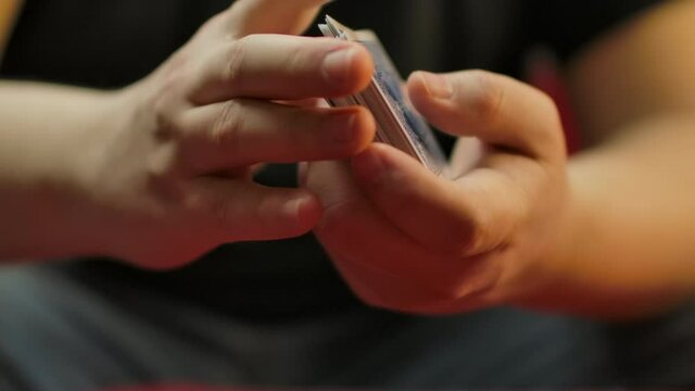 Slow motion closeup of hands shuffling a deck of cards.