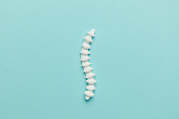 Spine treatment. Organ model lying on a blue background with pills.