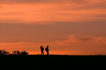 Fototapeta na wymiar people walking in the country with a beautiful sunset