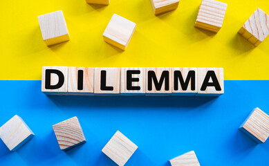 Word DILEMMA on wooden cubes with word on beautiful yellow and blue background. Business, media...