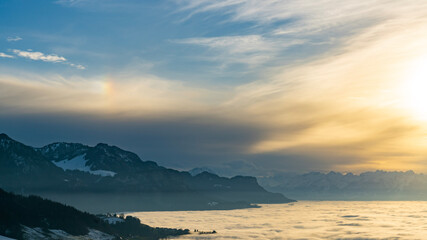 Fototapeta premium Abendsonne mit Halo über dem Nebelmeer im Rheintal in Oberbildstein. sunset over the sea of fog in the Rhine valley. Vorarlberg mit Säntis im Hintergrund