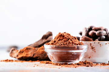 Organic cocoa powder, beans, grated lump on gray background. Copy space