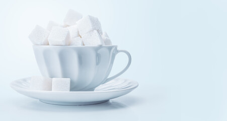 Tea cup filled full of white sugar cubes