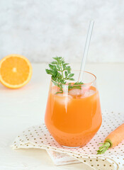 Glass of carrot juice smoothie in lifestyle scene. Copy concept.