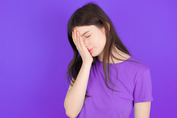 Fototapeta premium young beautiful Caucasian girl wearing purple T-shirt over purple background with sad expression covering face with hands while crying. Depression concept.