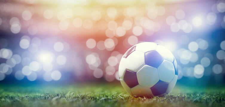 Football soccer ball on grass field on stadium