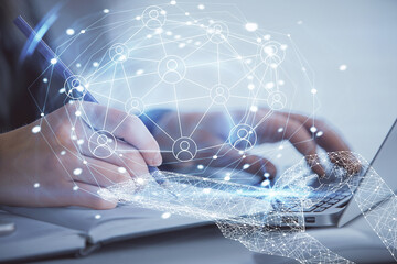 Double exposure of woman hands typing on computer and social network theme hologram drawing. People...
