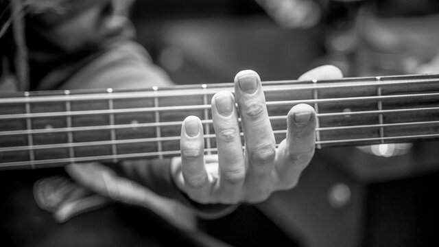 musician playing guitar black and white image, close up