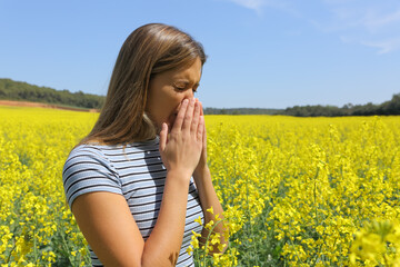 Allergic woman coughing in a yellow field