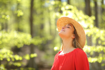 Woman in red breathing fresh air in a forest