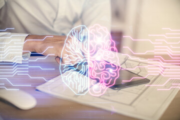 Double exposure of man's hand holding and using a digital device and brain hologram drawing. Data...