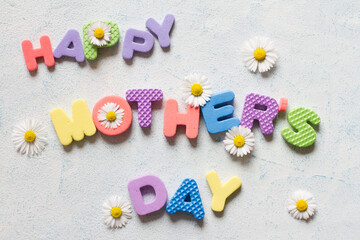 Lettering happy mother's day. Mother's day composition with colorful letters and daisies 