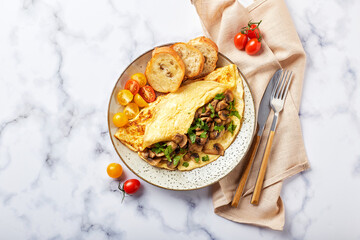 Omelet with champignons and parsley in plate on marble background. Frittata - italian omelet for breakfast or lunch. Flat lay.