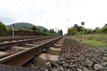 Fototapeta na wymiar Railroad tracks and railroad ties leading straight to a far distance