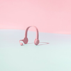 Pink earphones against pastel pink blue background