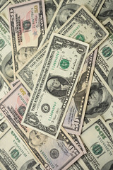 A money pile of various US banknotes with president Washington portrait on top. Cash of dollar bills, paper currency background.