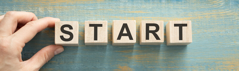 Start now or later symbol. Businessman turns wooden cubes and changes words 'start later' to 'start'. Beautiful grey background, copy space. Business and start now or later concept. - obrazy, fototapety, plakaty