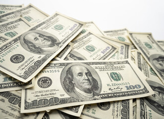 A money pile of one hundred US banknotes with president Franklin portrait on white background. Cash of hundred dollar bills, paper currency background.