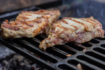 Two pieces of pork neck are grilled on the grill. Weekend