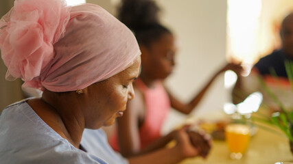 Woman praying at breakfast table