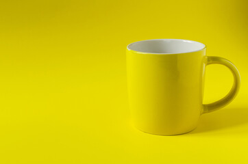 Abstract background yellow ceramic mug on yellow background close-up, concept. Bright yellow copy space mug