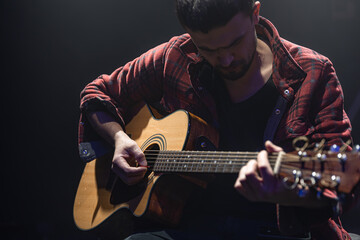 Obraz premium Male guitarist playing acoustic guitar close up.