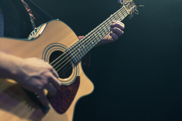 Obraz na płótnie Canvas Guitarist playing acoustic guitar in the dark.