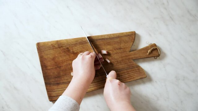 Slicing Italian bacon pancetta guanciale on a wooden board