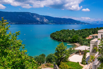 Beautiful summer landscape with sea resort -turquoise colored calm water, mountains and beach. Corfu Island, Greece
