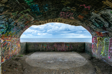 view of the sea from the opening of a bunker on the shore