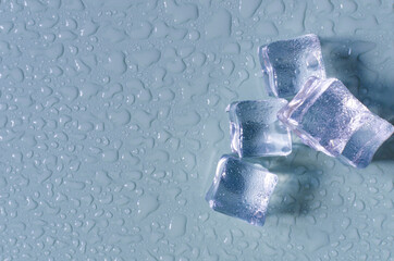 Transparent artificial ice cubes on a blue background. Background of transparent ice cubes and...