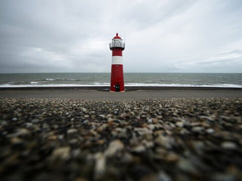 Panorama view of red white striped lighthouse tower Vuurtoren Noorderhoofd in Westkapelle Zeeland Netherlands North Sea