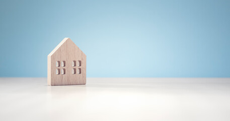 Wooden model house on blue background