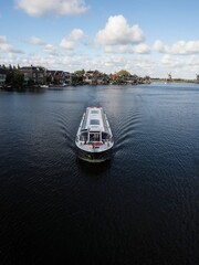 Excursion boat cruise and typical traditional house windmill in Zaanse Schans river canal Zaandijk...