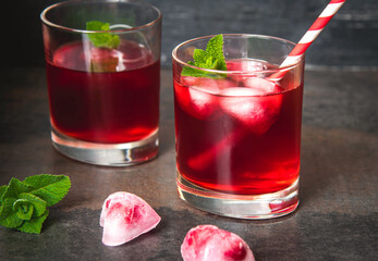 Berry cocktail with heart shaped ice cubes on a dark background