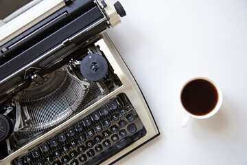 Old vintage typewriter and a cup of coffee nearby.