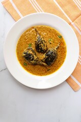 Baghare baingan, Baingan masala, Eggplant or brinjal curry, Bharli vangi. Khare vanga served in white plate. Copy space.