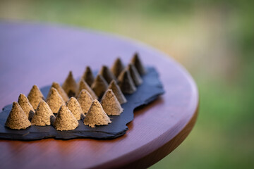 Some hand-made conical moxa used in traditional Chinese medicine is placed on a stone slab. Moxa close-up. Moxa creative photography.