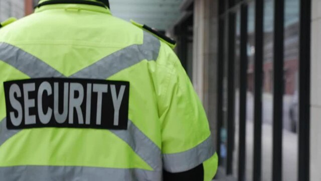A security guard watching and patrolling a street in a city.