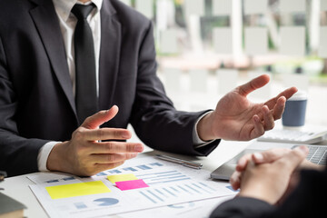 Two businessmen are discussing about earnings on a graph to plan investments.